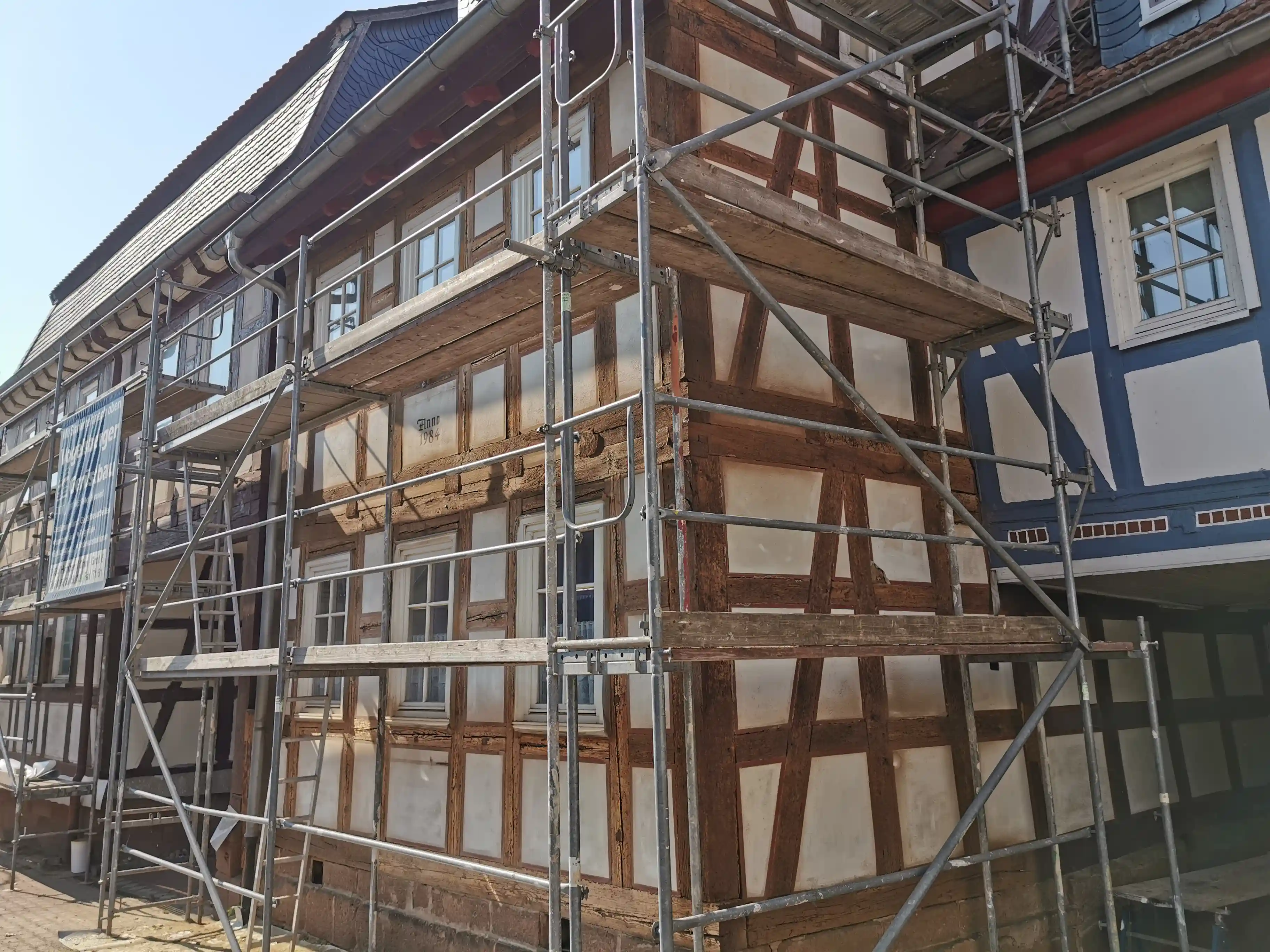 Fachwerkhaus mit sichtbaren Holzbalken während der Oberflächenbehandlung